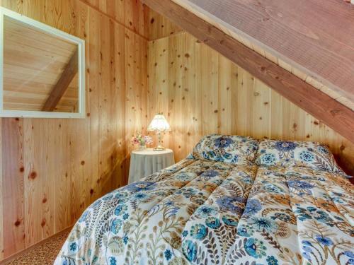 a bedroom with a bed in a room with wooden walls at The Chalet on Lopez in Islandale