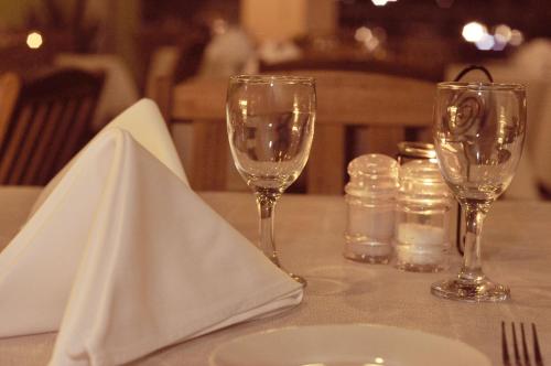 a table with two wine glasses and a plate at Zara's Boutique Hotel @ Harbour City in Kota Kinabalu