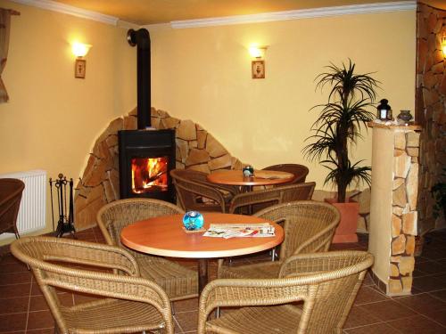 a restaurant with tables and a stone fireplace at Hotel Altenberg in Staré Hory