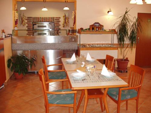 a dining room with a wooden table and chairs at Hotel Altenberg in Staré Hory