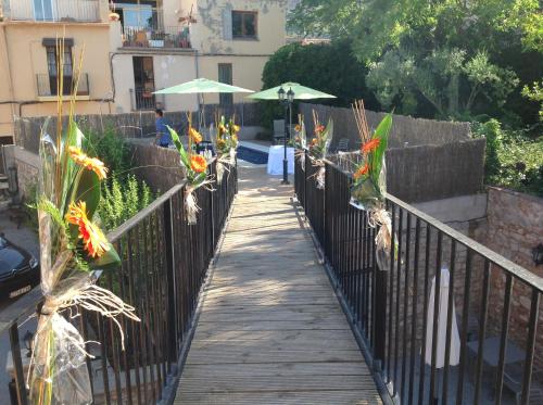 a wooden walkway with flowers on a fence at Can Misse in Collbató