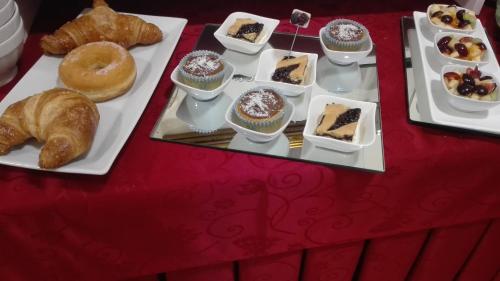 een tafel met verschillende soorten gebak en taarten bij Incantea Resort in Tortoreto Lido