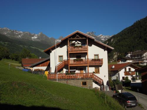 a large white building with a balcony on a hill at Möslehof in Kauns
