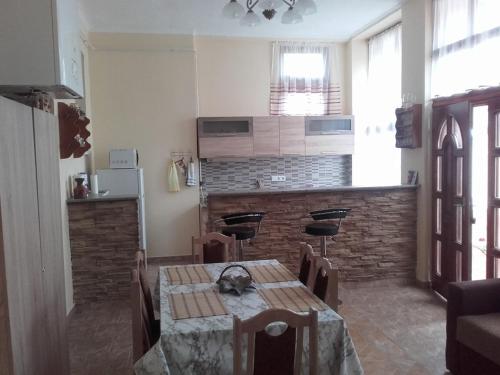 a dining room with a table and a kitchen at Réka Vendéghàz in Tokaj