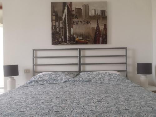 a bedroom with a bed and a picture on the wall at Residence Shopping Outlet in Novi Ligure