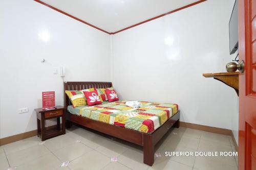 a small bedroom with a bed and a table at Hotel Georgina in Maitim