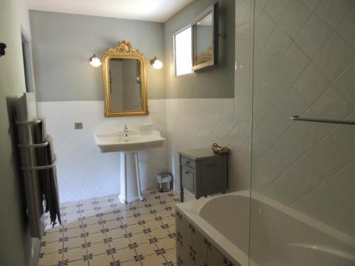 a bathroom with a sink and a mirror and a tub at Nabat le Haut, chambre et table d'hotes in Courniou