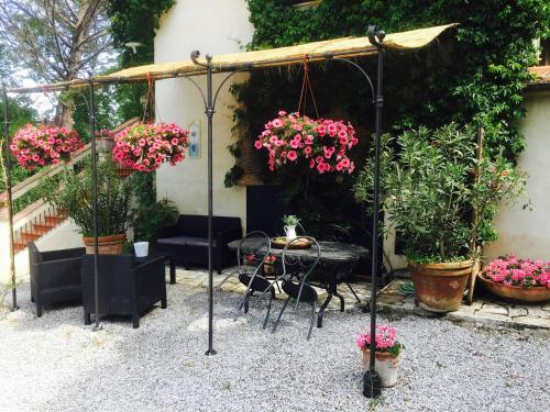 a patio area with a table, chairs, and a flower arrangement at Agriturismo Il Paradiso in Asciano