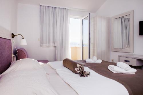 a hotel room with two beds and a window at Villa Palloma in Baška Voda