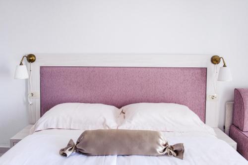 a white bed with a purple headboard with a pillow at Villa Palloma in Baška Voda