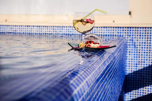 a glass of wine sitting on the edge of a swimming pool at Villa Palloma in Baška Voda