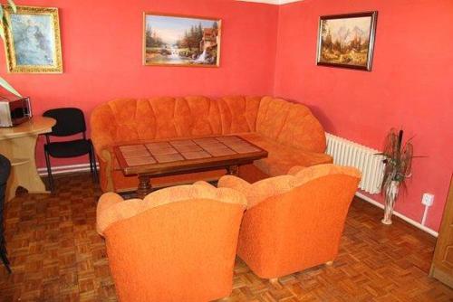sala de estar con sofá naranja y mesa en Ubytování u Šimků, en Hříběcí