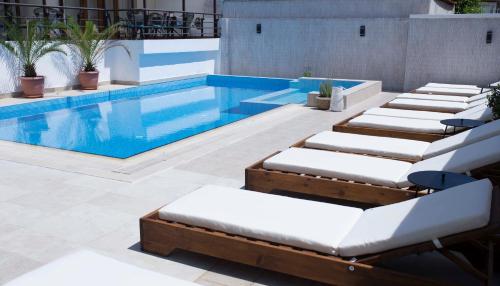 a pool with chaise lounge chairs next to a swimming pool at Ema Hotel in Sozopol