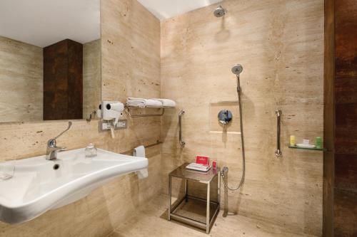 a bathroom with a sink and a shower at Ramada by Wyndham Navi Mumbai in Navi Mumbai