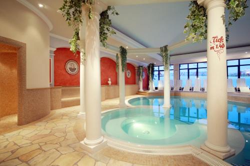 a swimming pool with columns in a hotel at Hotel Wagner in Obertauern