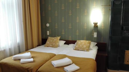 a bedroom with two beds with towels on them at Kesähotelli Aurora in Tampere