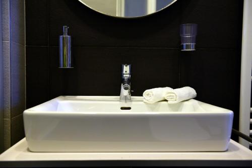 a white sink in a bathroom with a mirror at Downtown Deluxe in Budapest