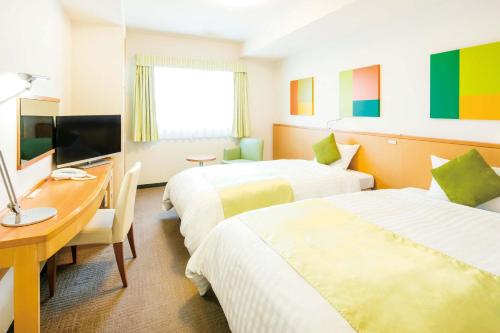 a hotel room with two beds and a desk at Hotel Lumiere Nishikasai in Tokyo