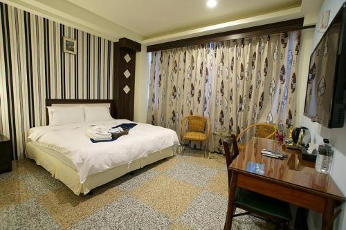 a bedroom with a bed and a desk and a desk at 台東市安慶67套房館歡迎短租長租 in Taitung City