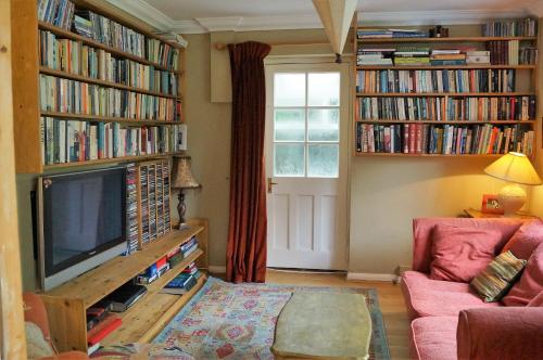 a living room with a tv and books at Inkerman in Lavant