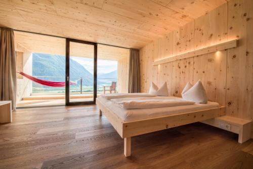 a bedroom with a bed and a large window at Bio Hotel Panorama in Malles Venosta