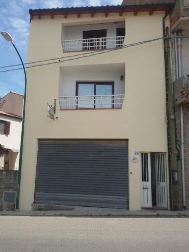 a white building with a large garage door at B&B S'Apposentu in Arbus