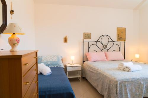ポリニャーノ・ア・マーレにあるVilla Margheritaのベッドルーム1室(ベッド2台、ドレッサー付)