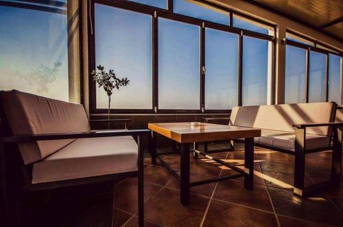 a room with a table and chairs and windows at Kochylari Apartments in Kefalos