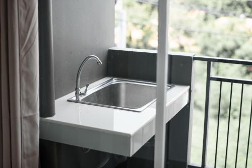 a sink on a balcony with a window at 48 Metro Hotel in Bangkok
