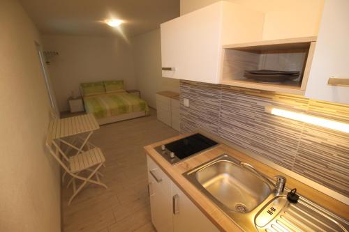 a small kitchen with a sink and a bed at Apartments Marinko in Stari Grad
