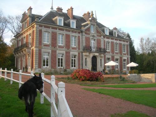 a dog standing on a fence in front of a house at Domaine de Vadancourt in Maissemy