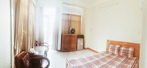 - une chambre avec un lit, une chaise et une fenêtre dans l'établissement Chang Homestay, à Nha Trang