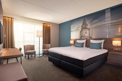 um quarto de hotel com uma cama e uma torre de relógio na parede em Van der Valk Hotel Groningen-Hoogkerk em Groningen