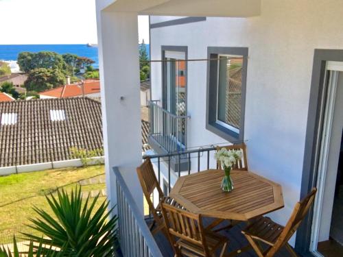 a table and chairs on a balcony with a view of the ocean at Casa do O in Ponta Delgada