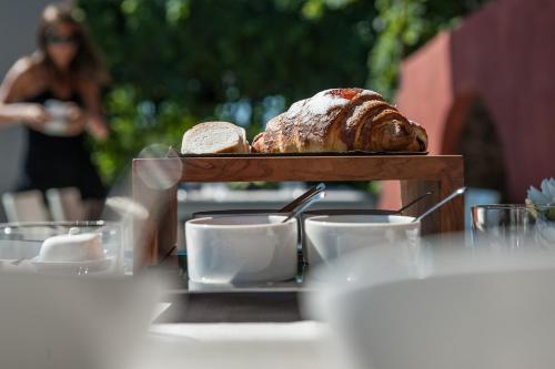 a table with a tray of bread and coffee cups at Zash Country Boutique hotel & SPA in Giarre