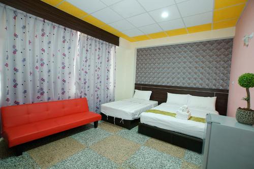 a bedroom with two beds and a red bench at 台東市安慶67套房館歡迎短租長租 in Taitung City