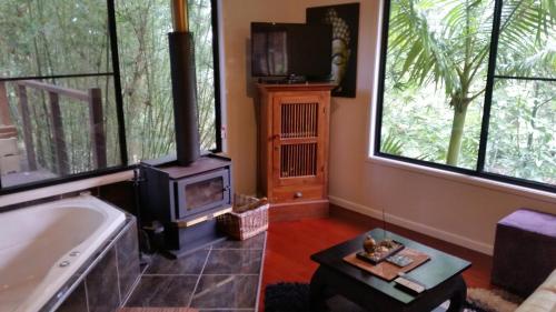 a living room with a tub and a stove at Alaya Ascend in Eudlo