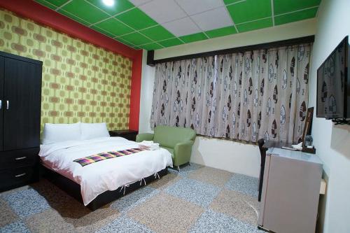 a bedroom with a bed and a green ceiling at 台東市安慶67套房館歡迎短租長租 in Taitung City