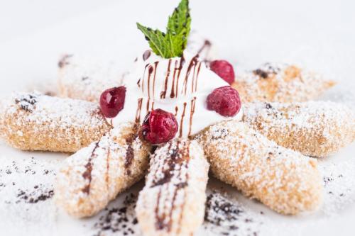 a dessert with powdered sugar and berries on a plate at Privat u Babky in Ždiar