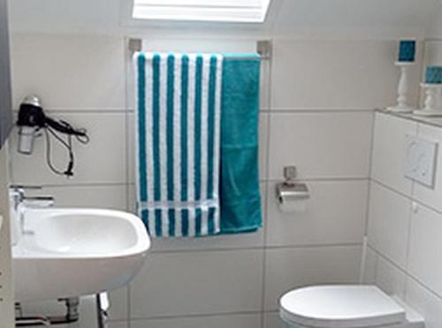 W łazience znajduje się umywalka, toaleta i ręcznik. w obiekcie Gasthaus Zur Linde w mieście Oberharmersbach