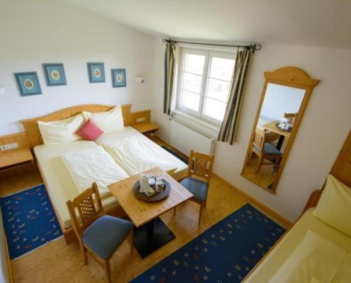 a bedroom with a bed and a table and a mirror at Bio-Pferdehof Fabian in Ludwigshof