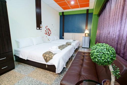 a bedroom with two beds and a couch in it at 台東市安慶67套房館歡迎短租長租 in Taitung City