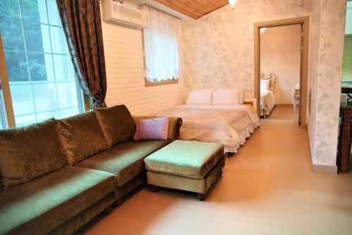 a living room with a couch and a bed at Shinevalley Pension & Hotel in Pyeongchang 