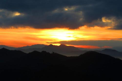 a sunset over a mountain range with the sun setting at b&b LATORDICELLA in Castel del Rio