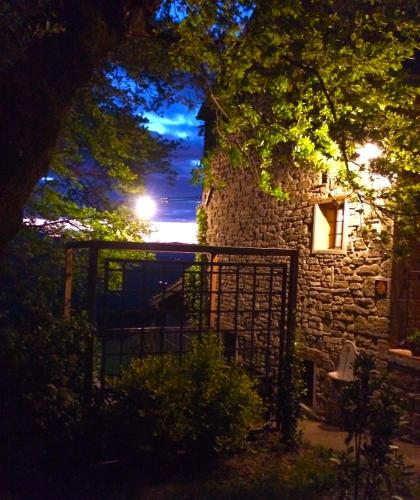 a stone building with a gate at night at b&b LATORDICELLA in Castel del Rio