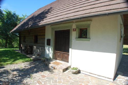 a small white house with a door and a porch at Chalet ApArt Kupljenik 12 A, Bled in Bohinjska Bela