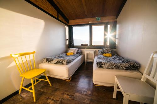 ein kleines Zimmer mit 2 Betten und einem Stuhl in der Unterkunft Geysir Hestar in Haukadalur
