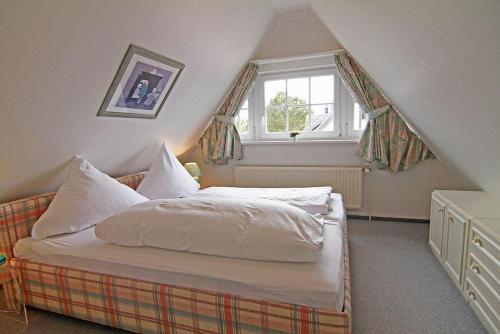 a small bedroom with a bed in a attic at Haus-Meisennest-Wohnung-Eule in Westerland (Sylt)