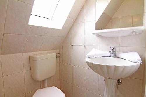 a bathroom with a sink and a toilet at Haus-Meisennest-Wohnung-Eule in Westerland
