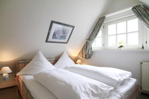 sypialnia z 2 białymi łóżkami i oknem w obiekcie Haus-Meisennest-Wohnung-Amsel w mieście Westerland
